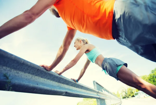 Primer plano de feliz pareja haciendo flexiones al aire libre —  Fotos de Stock