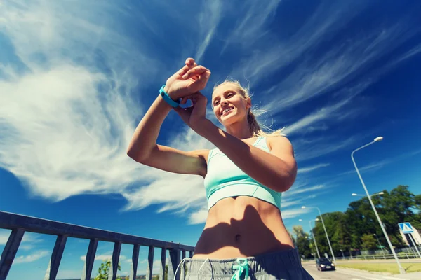 Happy woman with heart rate watch and earphones — Stock Photo, Image