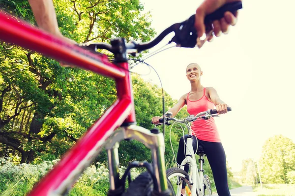 Close up of happy couple riding bicycle outdoors — Stock Photo, Image