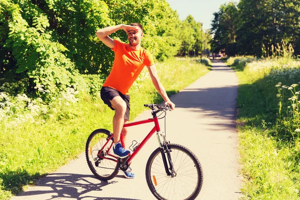 Glücklicher junger Mann, der im Freien Fahrrad fährt — Stockfoto