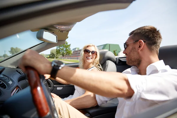 Feliz hombre y mujer conduciendo en coche cabriolet — Foto de Stock