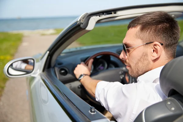 Happy man driving cabriolet car outdoors Stock Photo