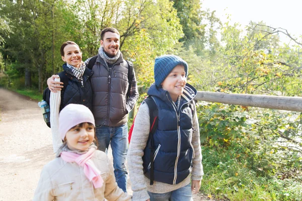 Famille heureuse avec sacs à dos randonnée dans les bois — Photo