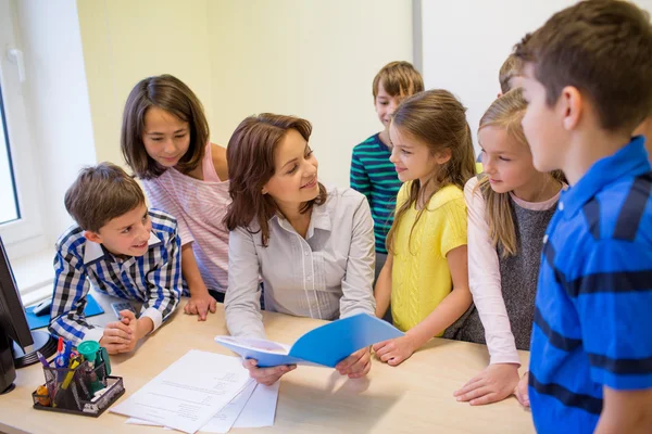 Group of school kids with teacher in classroom — Stock Photo, Image