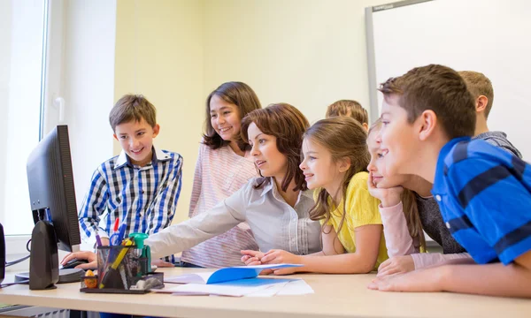 Groupe d'enfants avec professeur et ordinateur à l'école — Photo