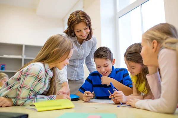 group of school kids writing test in classroom