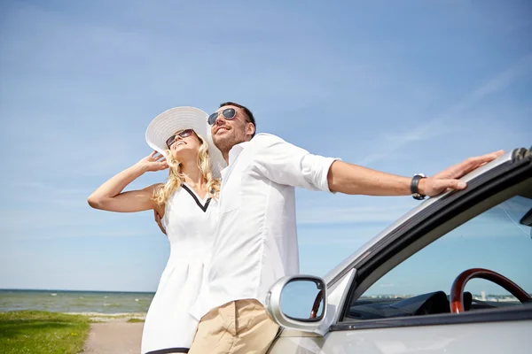 Lyckliga par kramas nära cabriolet bil till sjöss — Stockfoto
