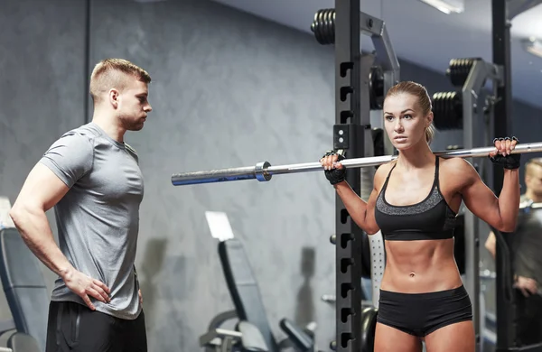 Spor salonunda halterli kadın ve erkek kaslarını esnetiyor. — Stok fotoğraf