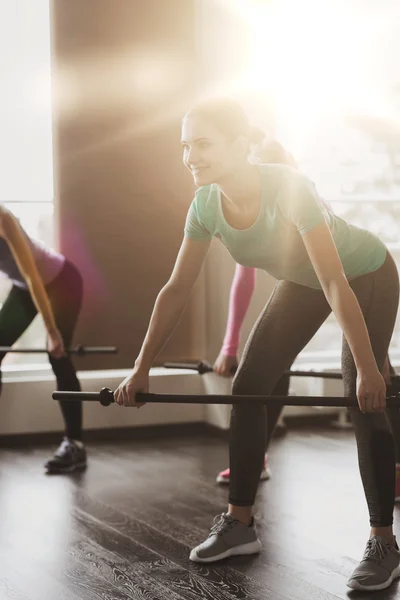 Groupe de personnes faisant de l'exercice avec des bars dans la salle de gym — Photo