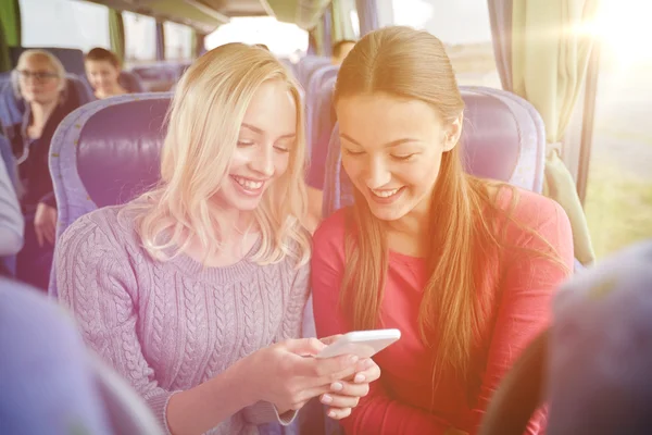 Mujeres jóvenes felices en autobús de viaje con teléfono inteligente —  Fotos de Stock