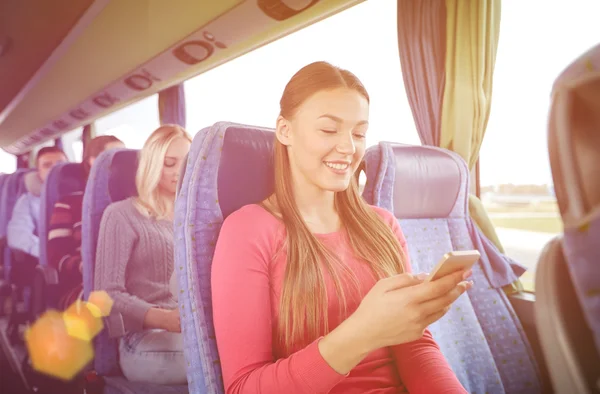 Ευτυχισμένη γυναίκα που κάθεται στο λεωφορείο ταξίδια με smartphone — Φωτογραφία Αρχείου