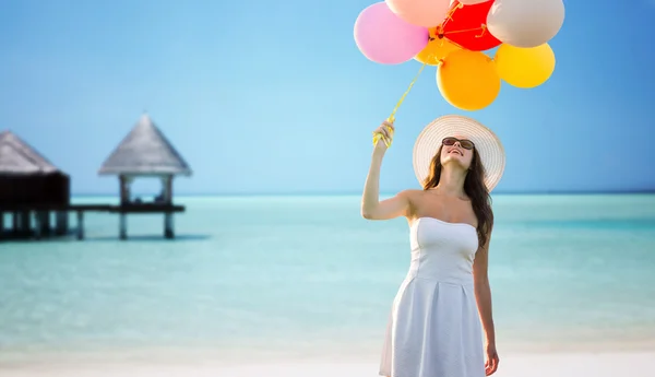 Smiling young woman in sunglasses with balloons — Stock Photo, Image