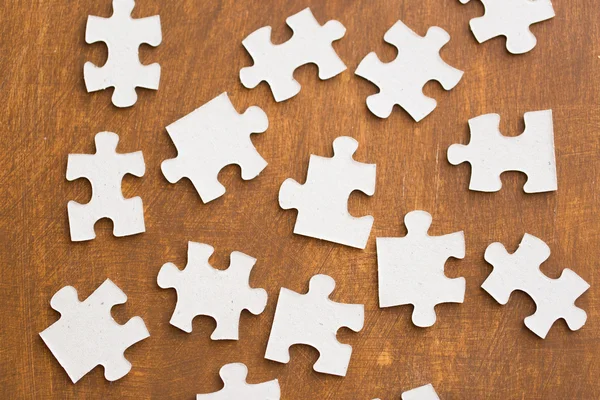 Close up of puzzle pieces on wooden surface — Stock Photo, Image