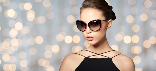 Mooie jonge vrouw in elegante zwarte zonnebril — Stockfoto