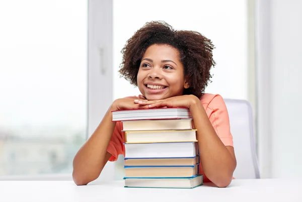 Счастливая африканская студентка с книгами дома — стоковое фото