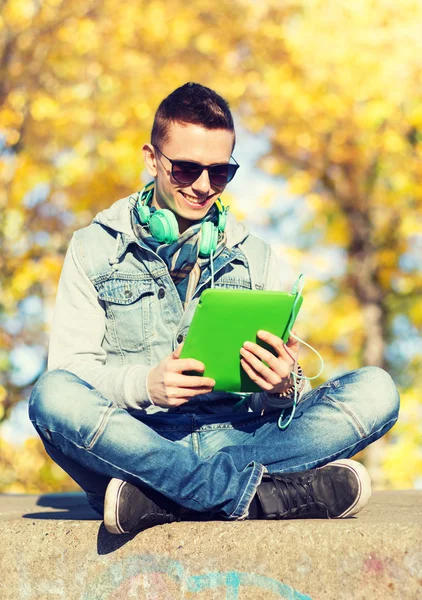 Glücklicher junger Mann mit Tablet-PC und Kopfhörer — Stockfoto