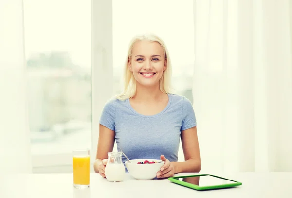 Mujer sonriente con tablet pc desayunando — Foto de Stock