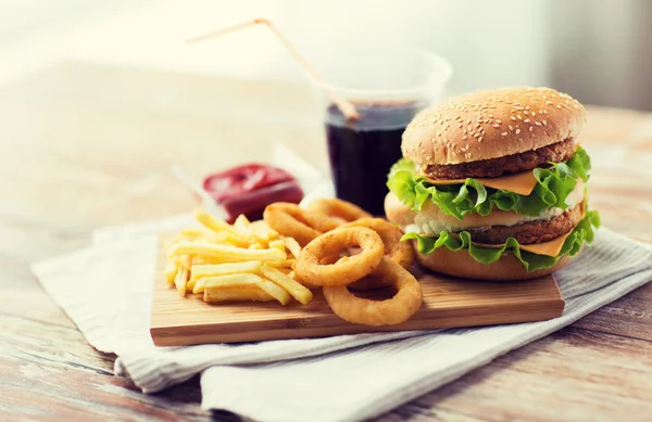 Close up of fast food snacks and drink on table — Stock Photo, Image