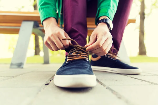 Primer plano de manos masculinas atando cordones de zapatos en la calle —  Fotos de Stock