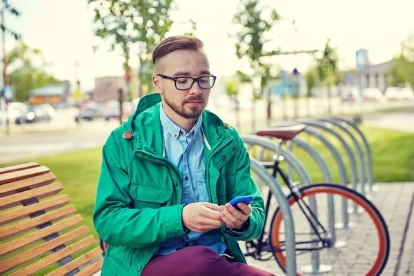 Gelukkig jonge hipster man met smartphone en fiets — Stockfoto