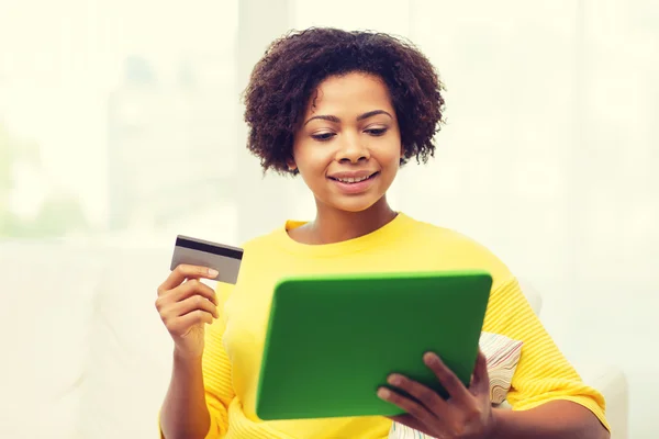 Boldog afrikai nő, a tábla-pc és a hitelkártya — Stock Fotó