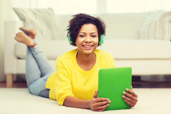 Mujer africana feliz con la PC tableta y auriculares — Foto de Stock