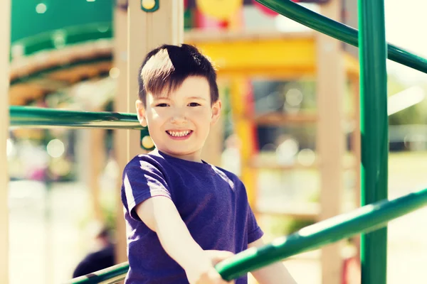 Niño pequeño y feliz escalada en el parque infantil — Foto de Stock