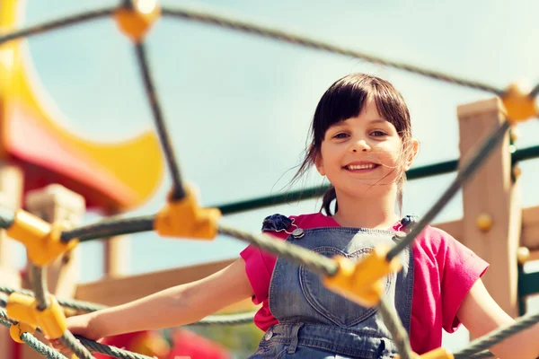 Fröhliches kleines Mädchen klettert auf Kinderspielplatz — Stockfoto