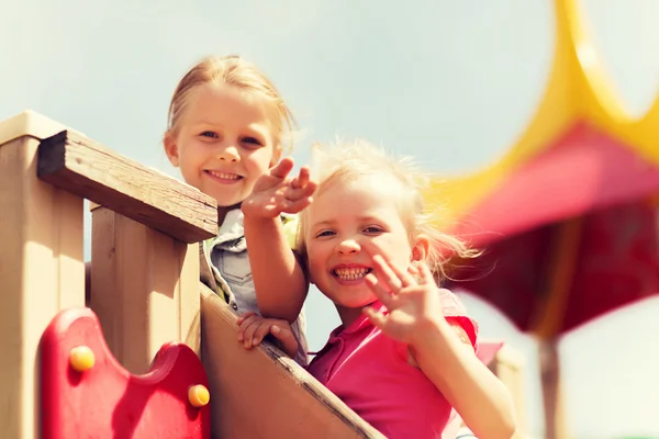 Glada tjejer viftande händer på lekplats — Stockfoto