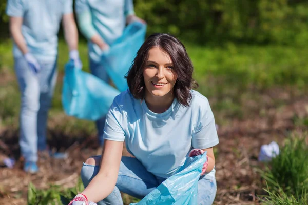 Voluntários com sacos de lixo área do parque de limpeza — Fotografia de Stock