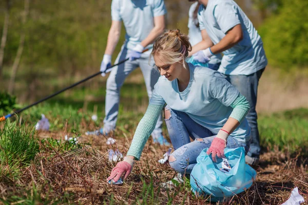 Volontari con sacchi della spazzatura pulizia area del parco — Foto Stock