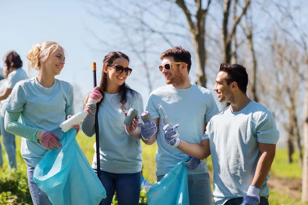 Relawan dengan kantong sampah membersihkan area taman — Stok Foto