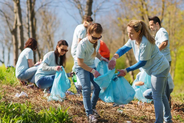 Bénévoles avec sacs à ordures nettoyage de la zone du parc — Photo