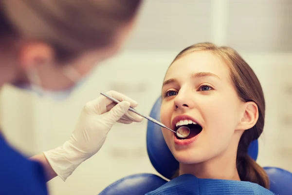 Dentista femenino chequeando dientes de niña paciente — Foto de Stock