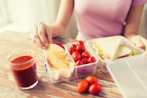 Close up of woman with food in plastic container — Stock Photo, Image