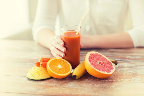 Närbild på kvinna händer med juice och frukt — Stockfoto