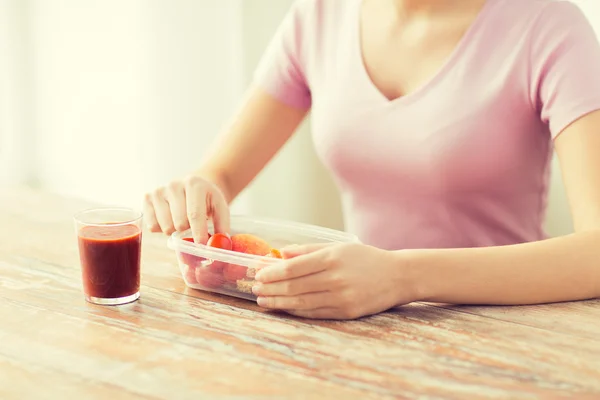 Close up of woman with food in plastic container — Stock Photo, Image