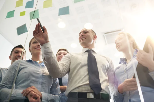 Smiling business people with marker and stickers — Stock Photo, Image