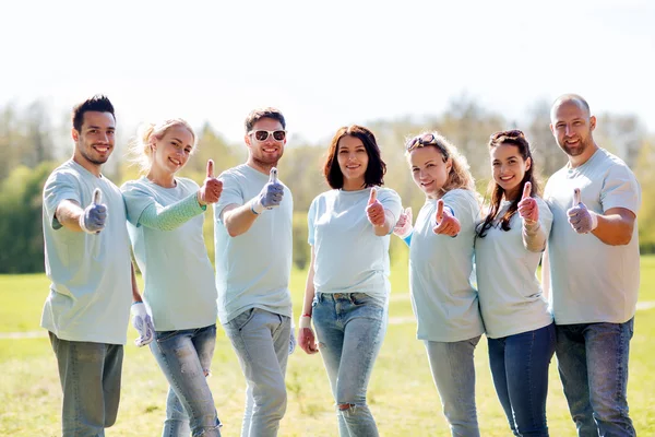 Grupo de voluntarios mostrando pulgares hacia arriba en el parque — Foto de Stock