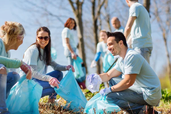 Volunteers with garbage bags cleaning park area — Stock Photo, Image