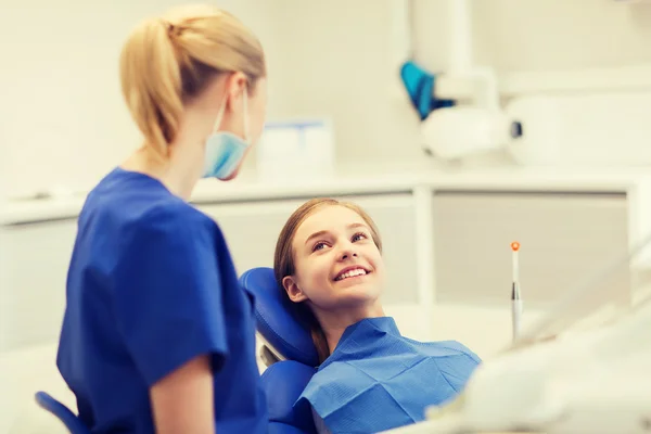 Dentista mujer feliz con chica paciente en la clínica —  Fotos de Stock