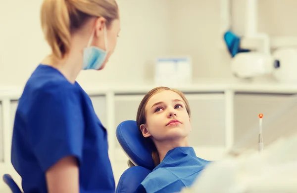 Dentista mujer feliz con chica paciente en la clínica —  Fotos de Stock