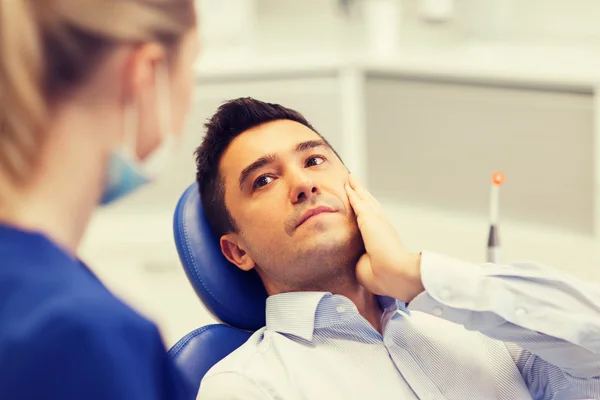 Female dentist and male patient with toothache — Stock Photo, Image