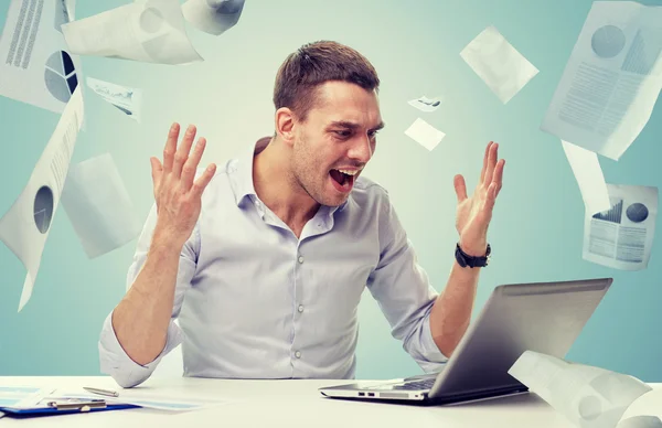 Dühös üzletember kiabálva papírok és laptop — Stock Fotó