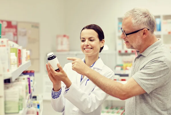 Farmacista che mostra droga all'uomo anziano in farmacia — Foto Stock