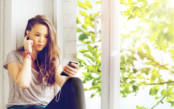 Menina adolescente com smartphone e fones de ouvido — Fotografia de Stock