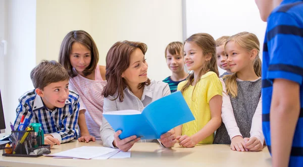 Group of school kids with teacher in classroom — Stock Photo, Image