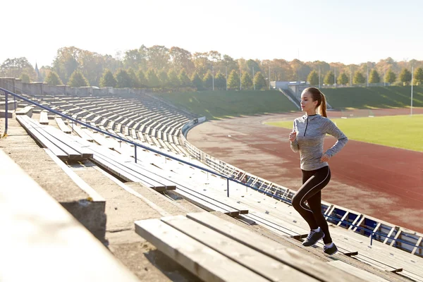 Feliz joven corriendo arriba en el estadio — Foto de Stock