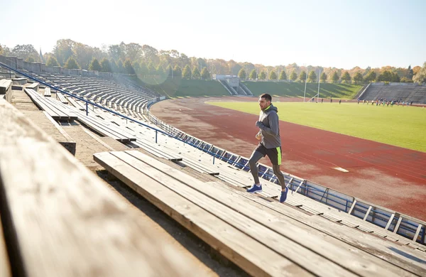 Heureux jeune homme courant à l'étage sur le stade — Photo