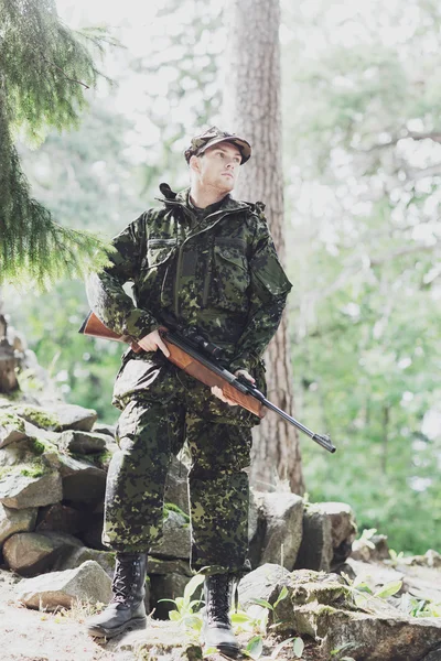 Ung soldat eller jägare med pistol i skogen — Stockfoto